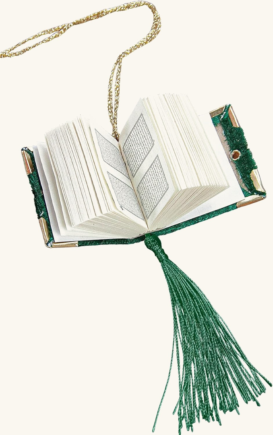 Mini velvet Quran opened to show Arabic pages, with green tassel and gold hanging cord